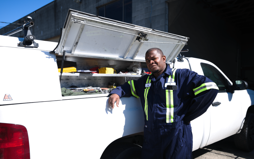 A mobile excavator mechanic poses beside their white truck, showcasing readiness for on-the-go equipment service and repair.